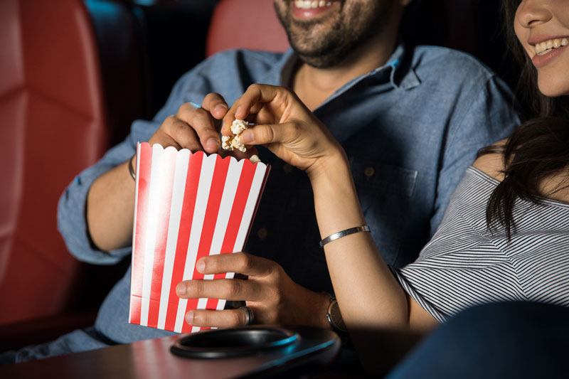 Close up of popcorn at the cinema with two people